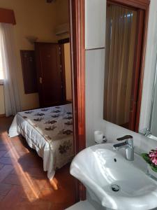 baño con lavabo y cama con espejo en Corte Degli Estensi, en Formigine