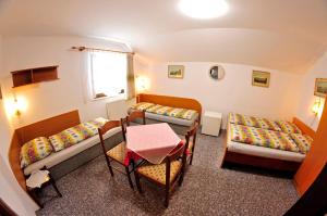 ヴルフラビーにあるPension 444 - Ski Resort Herlikovice and Bubakovのベッド2台とテーブルが備わる小さな客室です。