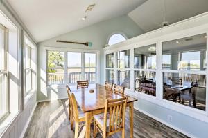 Un comedor con mesa y sillas y ventanas. en Cozy Waterfront Island House on Live Oak Island!, en Panacea