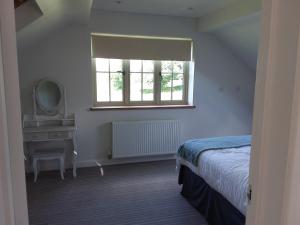 1 dormitorio con cama, espejo y ventana en Kneese Loft, en Chesterfield