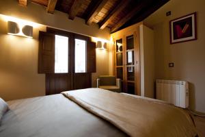 a bedroom with a large white bed with a window at El Romero in Hervás +33 photos
