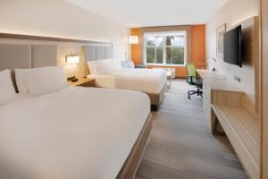 a hotel room with two beds and a desk at Holiday Inn Express & Suites S Lake Buena Vista by IHG in Kissimmee