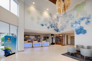 a waiting area of a library with chairs and a wall at Holiday Inn Express & Suites S Lake Buena Vista by IHG in Kissimmee