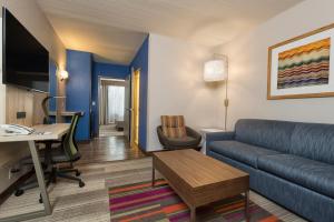 a living room with a couch and a desk at Holiday Inn Express & Suites S Lake Buena Vista by IHG in Kissimmee