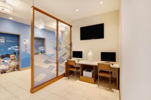 a room with a desk with two monitors on a wall at Holiday Inn Express & Suites S Lake Buena Vista by IHG in Kissimmee