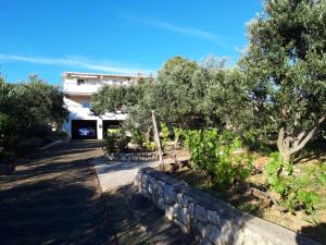 a house with trees and a stone wall at Apartment Gligora in Mandre