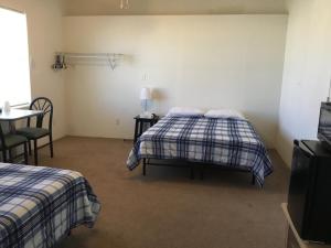 a bedroom with two beds and a table and a table at Casita in Pahrump