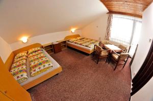 a room with two beds and a table and chairs at Pension 444 - Ski Resort Herlikovice and Bubakov in Vrchlabí +27 photos