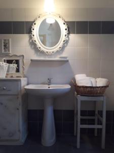 La salle de bains est pourvue d'un lavabo, d'un miroir et d'un tabouret. dans l'établissement Agriturismo L'Essiccatoio, à Corgna