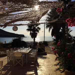 a table with chairs and a table with a view of the ocean at Sunset Studios & Rooms in Antiparos