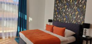 a bedroom with a bed with a large painting on the wall at Grand Paradise Apartman in Miskolc +19 photos