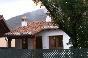 a house with a tiled roof with an orange tree at El Naranjo in Casas del Monte
