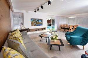 a living room with a couch and chairs and a table at וילה דולב in Eilat