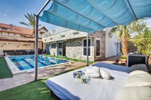 a bed in the backyard of a house with a swimming pool at וילה דולב in Eilat