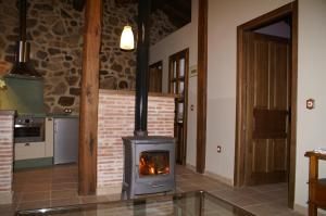 cocina con chimenea y fogones en El Naranjo, en Casas del Monte