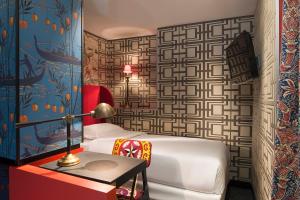 une chambre avec un lit et une table avec une lampe dans l'établissement Hôtel du Continent, à Paris