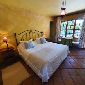 um quarto com uma cama grande com lençóis brancos em Hotel Posada Colchagua em Santa Cruz