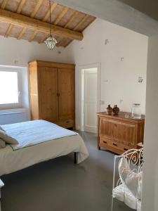 1 dormitorio con 1 cama y armario de madera en Casolare Sarò, en Morro dʼAlba