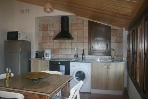 a kitchen with a washing machine and a table at Apartamentos Plan Dulcis in Buera