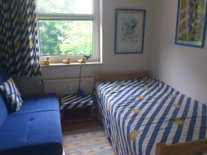 a bedroom with a bed and a couch and a window at Bella Boltenhagen in Boltenhagen