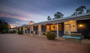 a building with a picnic bench in front of it at The Platypus Accommodation & Cafe in Cudal