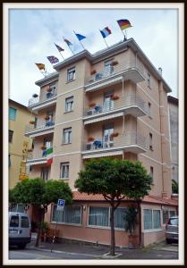 a tall building with flags on top of it at Hotel Del Golfo in Lerici