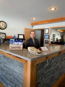 a man standing behind a counter in a store at Glacier Mountain Lodge in Blue River