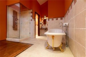 a bathroom with a tub and a shower and a sink at Palacio de Pujadas by MIJ in Viana