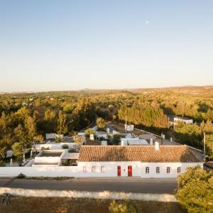 une vue aérienne sur un bâtiment blanc avec des toits rouges dans l'établissement Hospedaria, à Alvisquer