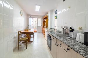 a kitchen with a counter and a table in it at Apartamento Vital Aza in Pola de Lena