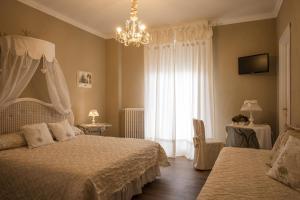 a bedroom with two beds and a chandelier at B&B Il Biancospino in Abbadia San Salvatore