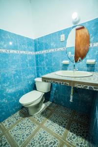 a blue tiled bathroom with a toilet and a sink at Hotel el Manglar in Bacalar
