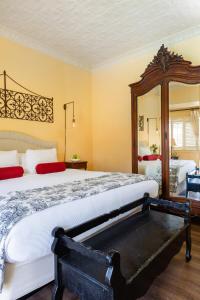 a bedroom with a large bed and a large mirror at Maison Fleurie, A Four Sisters Inn in Yountville