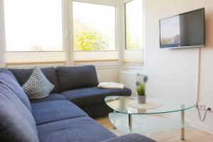 sala de estar con sofá azul y mesa de cristal en Haus-Strandburg-Seebriese, en Dahme