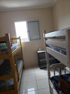 ein Zimmer mit zwei Etagenbetten und einem Fenster in der Unterkunft Apto. De frente pro Mar in Praia Grande
