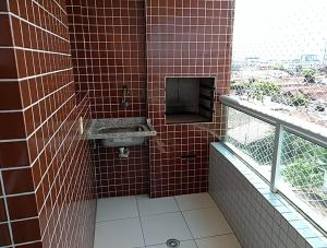 ein rot gefliestes Badezimmer mit Waschbecken und Fenster in der Unterkunft Apto. De frente pro Mar in Praia Grande + 18 Fotos