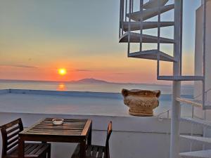 a table and chairs on a balcony with a sunset at B&B La Danza del Mare in Anacapri