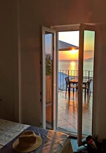 a bedroom with a door open to a balcony with a table at B&B La Danza del Mare in Anacapri