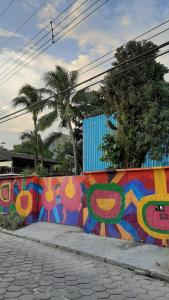 a wall with graffiti on it next to a sidewalk at Cantinho Maresias in Maresias