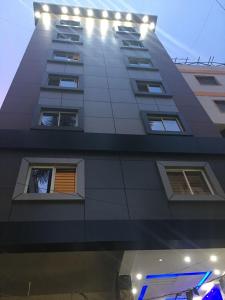 バンガロールにあるHotel Grand Suitesの上部に照明が付いた高い建物 +16枚の写真
