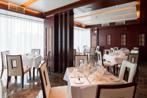 une salle à manger avec des tables et des chaises blanches dans l'établissement Best Western Plus Pearl Addis, à Addis-Abeba