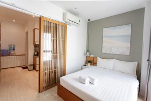 een slaapkamer met een groot wit bed en handdoeken bij The Art - Sunshine Apartment in Ho Chi Minh-stad