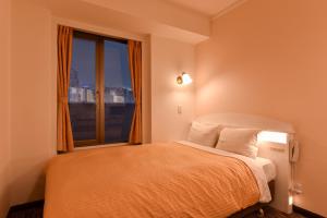 a bedroom with a bed with a large window at Kobe Sannomiya Union Hotel in Kobe