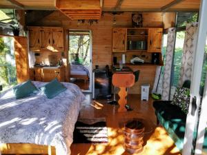 1 dormitorio con 1 cama y cocina en una cabaña en Cabaña treehouse Mountain View en San Isidro