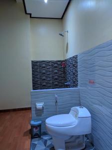 a bathroom with a white toilet in a room at Indah Nusantara in Banyuwangi
