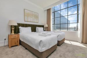 オークランドにあるQV Glamour 2 Bedroom Apt with Carpark - 758のベッドが2つと大きな窓がある寝室 +12枚の写真