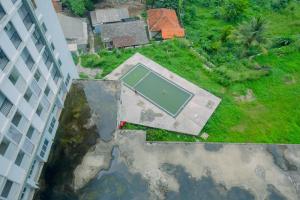 an overhead view of a swimming pool in a yard next to a building at Comfy Studio Bogorienze Apartment near The Jungle Fest By Travelio in Bogor