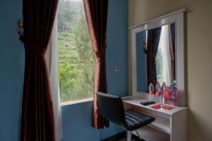 RedDoorz @ Gerbang Dieng Plateau Area في وونوسوبو: مكتب مع مرآة وكرسي بجوار النافذة