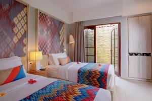 Aruna Senggigi Resort & Convention في سينغيغي: غرفة فندقية بسريرين ونافذة