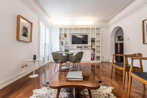 sala de estar con mesa, sillas y TV en Manor House Lima, en Lima